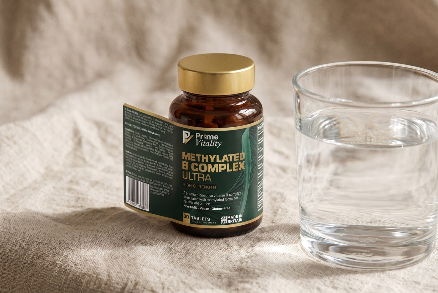 Prime Vitality Methylated B Complex Ultra bottle on a linen surface beside a glass of water